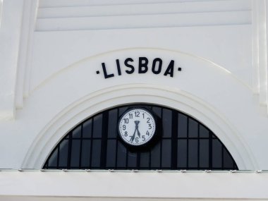 Lisboa kelimesi ve saati olan beyaz bir binaya yakın çekim.
