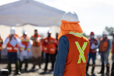 Takım lideri, bir toplantıda teknisyen, ustabaşı ve mühendis ekibine iş veriyor.