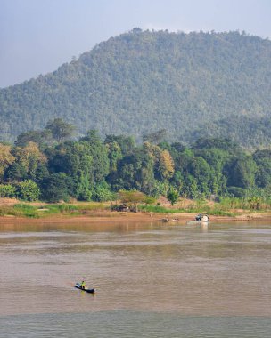 Mekong Nehri 'nin Luang Prabang, Laos' taki dağların yakınında yüzen bir tekneyle çekilmiş dikey görüntüsü.