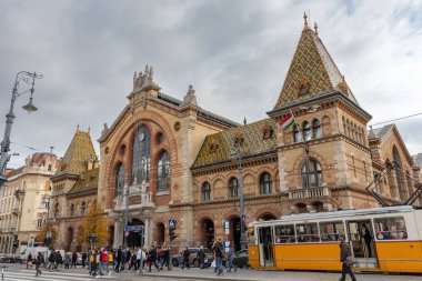 Macaristan 'ın Budapeşte kentindeki Merkez Market Salonu önünde karşıdan karşıya geçen insanların düşük açılı yakın çekim görüntüleri.