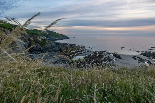 落日时带着大海的岩石山覆盖的海岸 — 图库照片