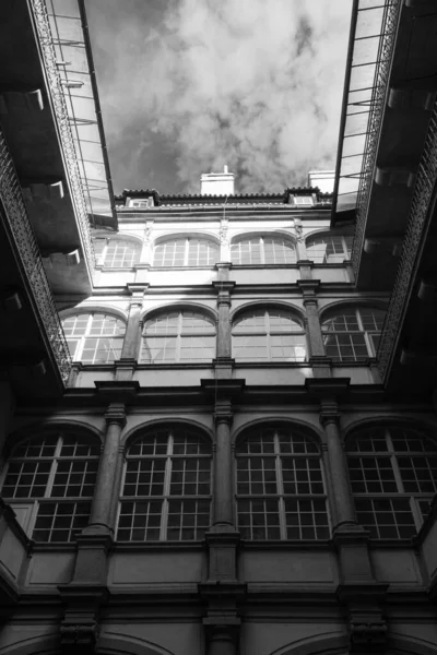 Gråskala Lav Vinkel Fasade Bygning Med Buemønster Glassvinduer Skyet Himmel – stockfoto