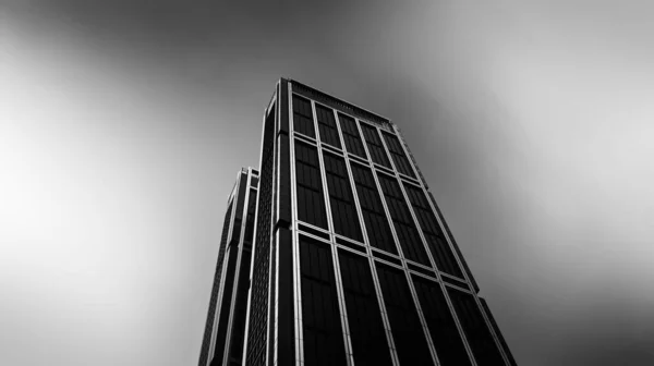 Grayscale Záběr Černé Moderní Budovy Pod Bouřlivou Oblohou — Stock fotografie