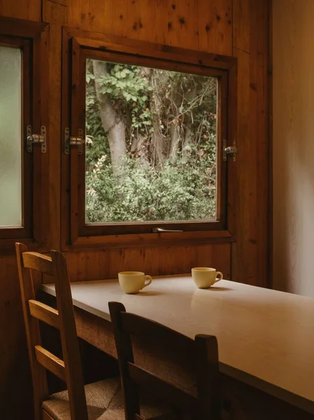 居心地の良い環境で窓の隣に置かれた木製のテーブルの垂直ショット — ストック写真