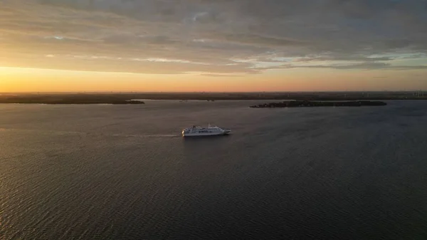 美しい夕日を背景に海岸沿いを航海するクルーズ船の景色 — ストック写真