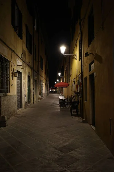 夜景中一条狭窄街道的垂直拍 墙上点着灯光 — 图库照片