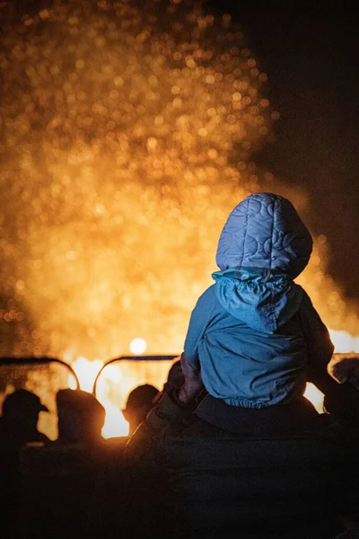 夜のたき火の炎の前に子供と群衆の垂直方向のビュー — ストック写真