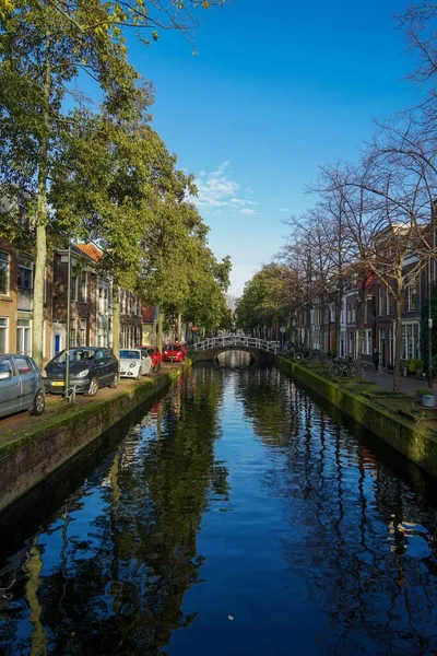 アムステルダム市内中心部近くの古い運河で 遠くに橋が見えます — ストック写真