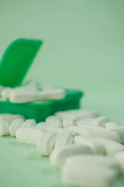 Eine Vertikale Nahaufnahme Weißer Pillen Einer Grünen Pillbox Auf Weißem — Stockfoto