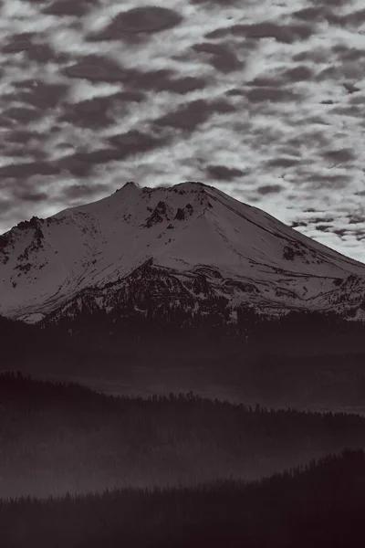 Ένα Βουνό Καλυμμένο Χιόνι Ενάντια Ένα Συννεφιασμένο Ουρανό Γκρι Βολή — Φωτογραφία Αρχείου