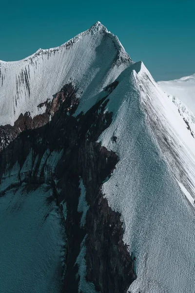 一道美丽的垂直的雪峰映衬在蓝天上 — 图库照片