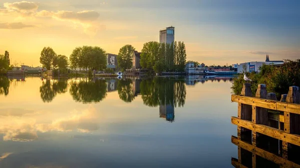 Reflection Buildings Leafy Trees Still Mirror Lake Captured Sunset — Stock Photo, Image