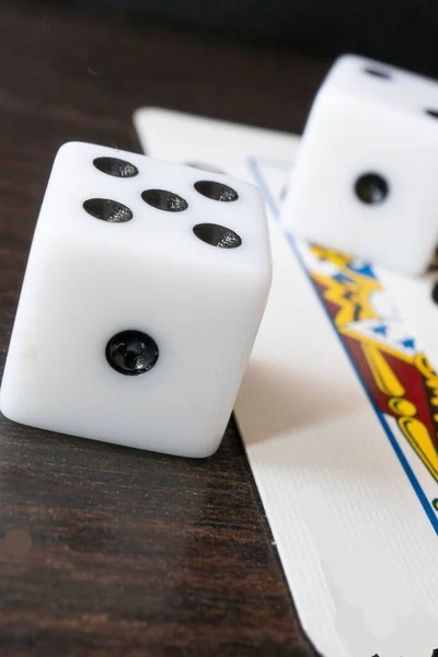 一张赌博骰子和扑克牌在木制桌子上的垂直特写照片 — 图库照片