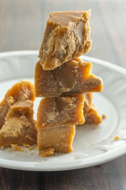 Bir tabakta üst üste dizilmiş Mysore Pak çubuklarının dikey görüntüsü.