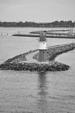 Taşların üzerindeki küçük deniz fenerinin dikey görüntüsü.