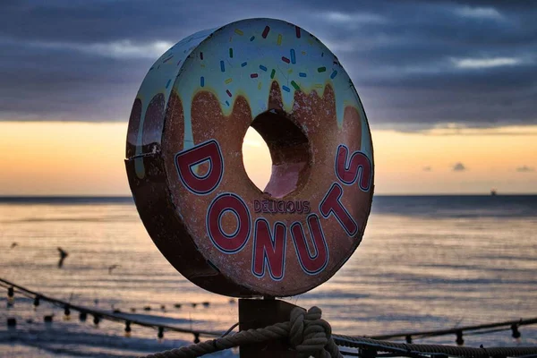 Closeup Shot Doughnut Sign Seafront Shop Sunrise Background Isle Wight — Stock Photo, Image