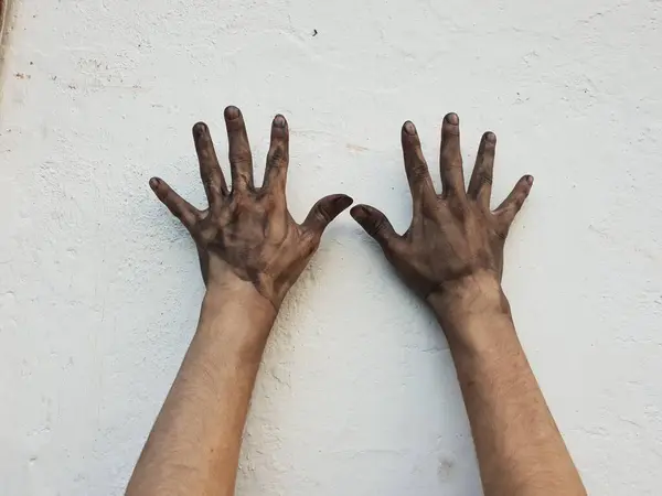 白いコンクリートの壁の背景に汚れた手の閉鎖 — ストック写真