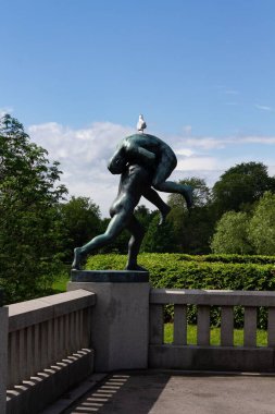 Norveç 'in Oslo kentindeki Vigeland parkında mavi gökyüzüne karşı çekilen modern bir heykelin dikey hali.