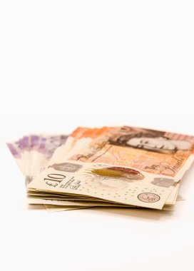 Beyaz arkaplana karşı 10 pound 'luk banknot yığını