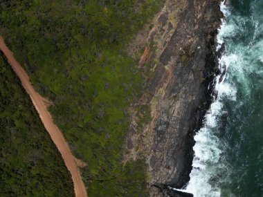 Uçurumun üzerindeki dar bir patikanın havadan görünüşü deniz kenarındaki doğa ile kaplıydı.