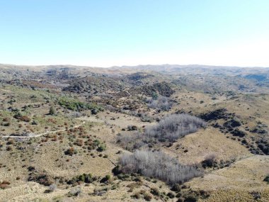 Güneşli bir günde vahşi tepelerin üzerinde bir manzara.