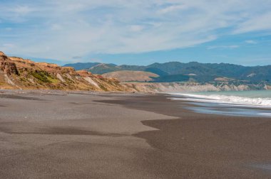 Wairarapa 'daki Palliser Körfezi' nin arkasında güzel bir manzara olan boş sahili.