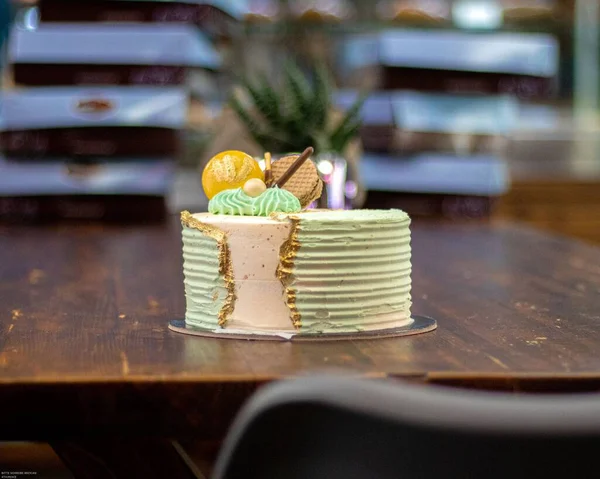 Eine Torte Mit Sahne Grün Und Rosa Auf Einem Holztisch — Stockfoto