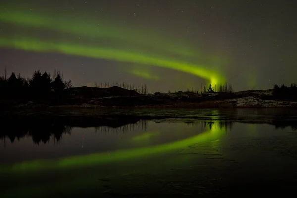 夜間にアイスランドの湖に反射するオーロラの風光明媚なショット — ストック写真