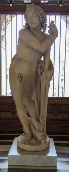 Pionowe Ujęcie Marmurowej Rzeźby Nagiego Adonisa Stojącego Opierającego Się Słup — Zdjęcie stockowe