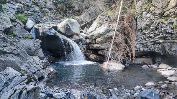 stock image A beautiful natural scene in the wilderness with a waterfall flowing into a pond surrounded by rocks