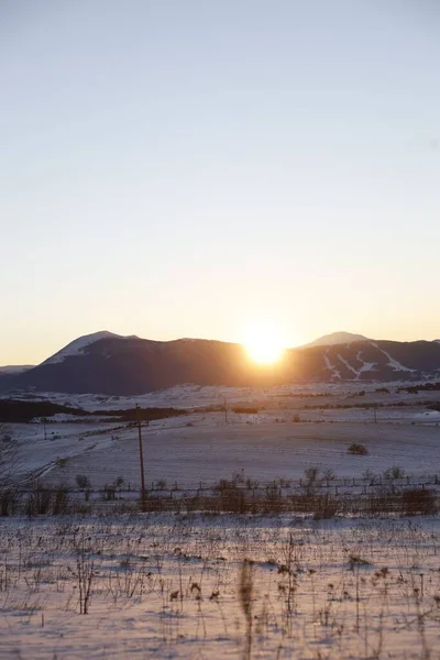 寒い冬と日の出の間に雪に覆われた山々の垂直画像 — ストック写真