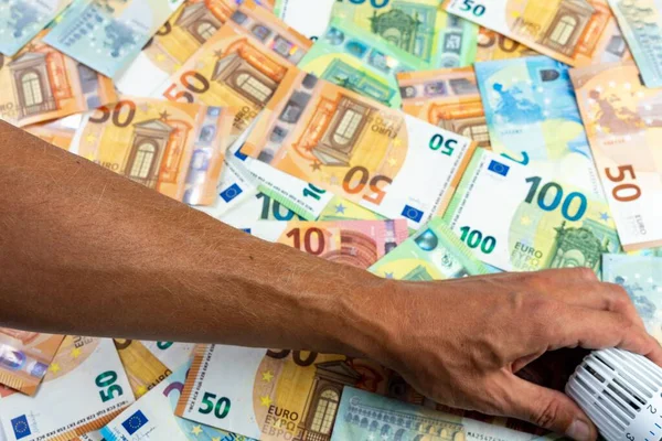 一名男子调整散热器恒温阀覆盖欧元钞票 冬季能源危机 — 图库照片