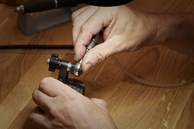 Ahşap fabrikasında ahşap bir masada aletle çalışan bir adamın yakın çekimi.