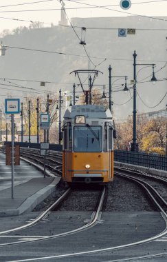 Macaristan, Budapeşte 'de gündüz vakti çekilen sarı tramvayın dikey görüntüsü.