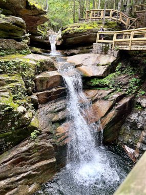 Tahta köprüleri olan bir dağ turistinin şelalesinin dikey görüntüsü.