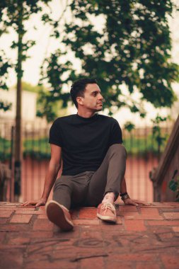 Parkta poz veren yakışıklı bir İspanyol 'un dikey çekimi..