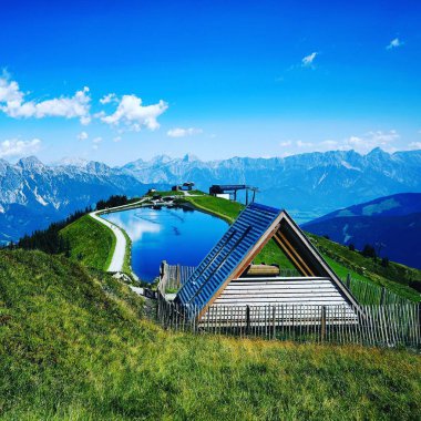 Leogang 'da güneşli bir günde dağlarla çevrili güzel bir göl.