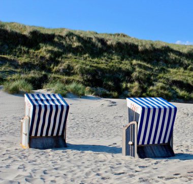 Almanya, Norderney 'de kumlu sahilde çizgili plaj sandalyeleri