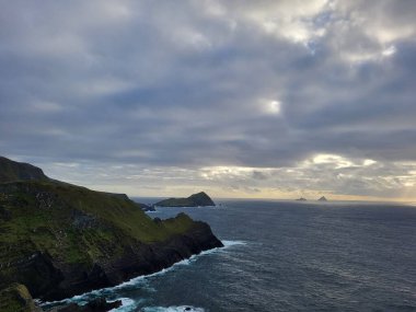 Gündüz vakti dağ oluşumları ve deniz kıyısına sahip manzaralı bir manzara.