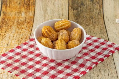 Brezilya Mini churro 'sunun yakın çekimi. Ahşap bir masada geleneksel bir atıştırmalık.