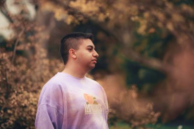 Mor kravat boyalı kazak giyen genç bir İspanyol.