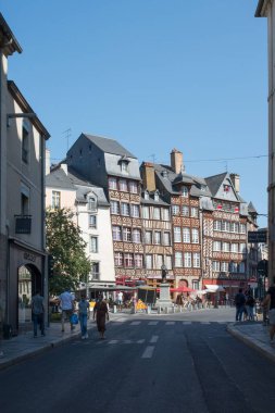 Rennes, Fransa 'da bir sokakta yürüyen insanlar mavi gökyüzünün altındaki eski tarz binalara karşı