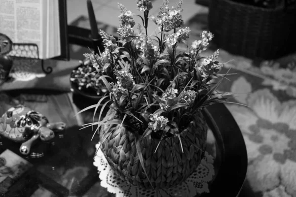 テーブルの上の籠の中で花の花束のクローズアップショット 背景に亀の図と グレースケールで 装飾の概念 — ストック写真
