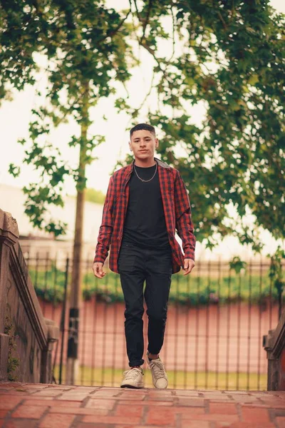 遊び場を歩いているハンサムな若い男の垂直ショット — ストック写真