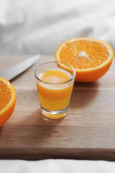 Egy Közeli Kép Vágott Narancsból Egy Pohár Narancslével Fedélzeten Fehér — Stock Fotó