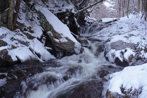 Ett Vattenfall Omgivet Stenar Täckta Med Snö Vintern — Stockfoto