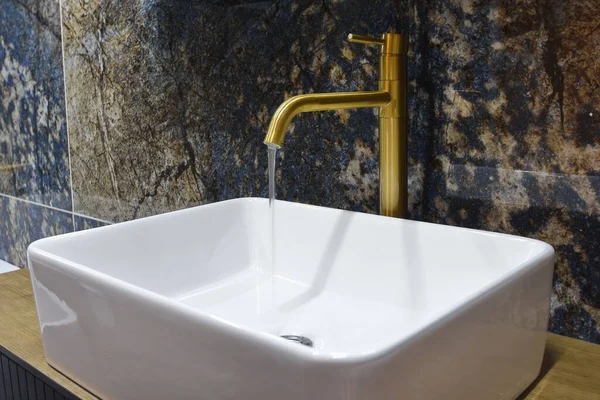在现代化的浴室里 一个装有金水龙头的水池的特写镜头 — 图库照片