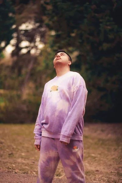 公園の紫のネクタイ染めのスポーツ衣装を着た若いヒスパニック系の男の垂直ショット — ストック写真