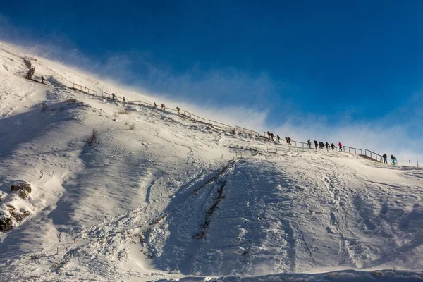 在冰岛 一个美丽的人在蓝天的映衬下爬上雪山 — 图库照片