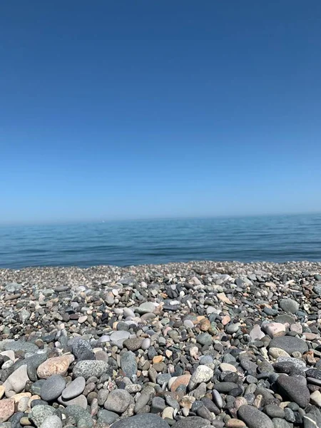 在一个晴朗的夏日里 佐治亚州巴统的一块卵石海滩与蓝色大海的垂直对比 — 图库照片